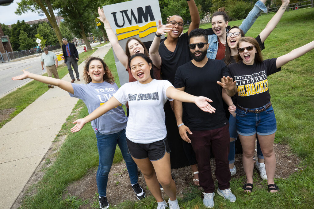 A group of students in front of UWM signage
