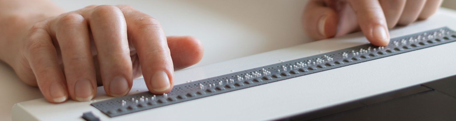 Blind person reads on braille display from computer screen
