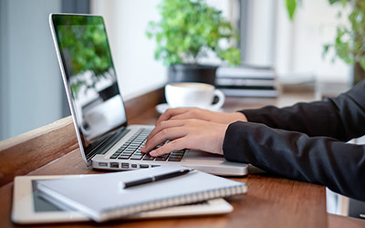 A person types on a laptop.