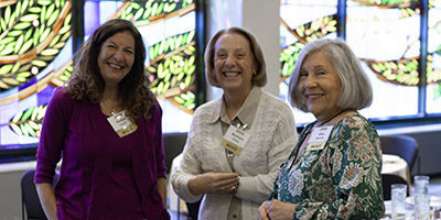 Three ladies pose for a photo at an event.