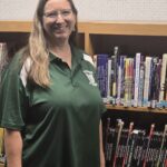 Rochelle standing in front of shelves of books.