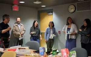 Six faculty members laughing and socializing