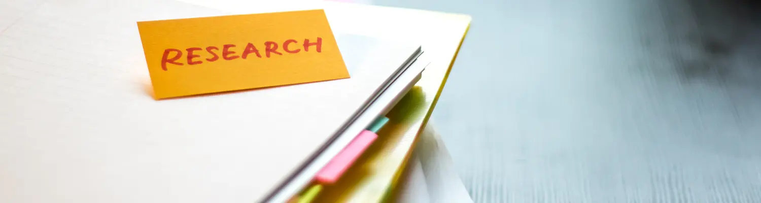 folders on table with "research" written on sticky note