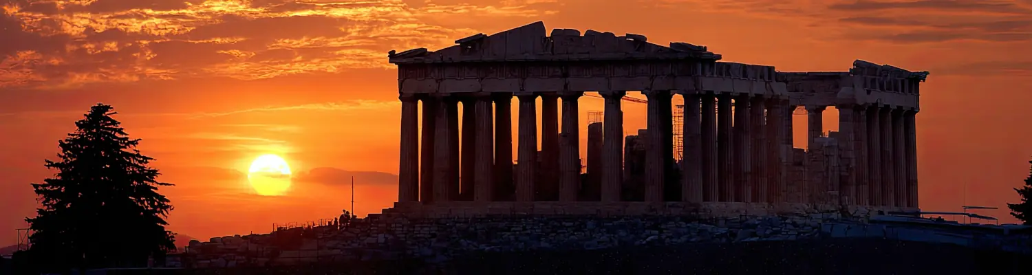 ancient columned building silhouetted by sunset
