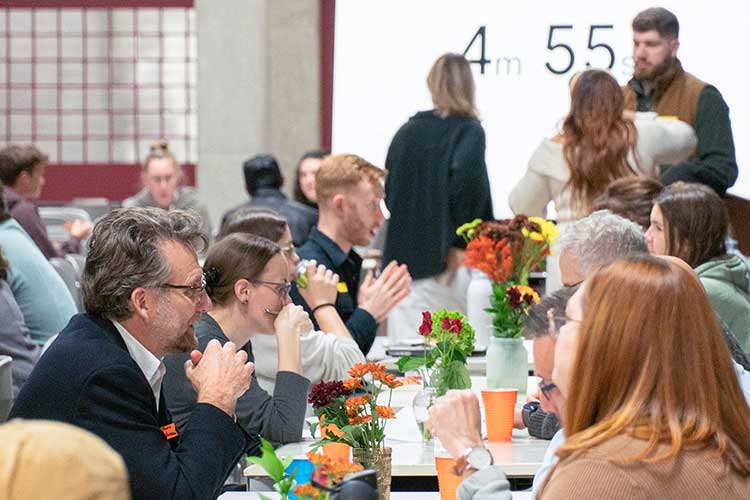 Female architecture students gather with industry professionals at a lunch event.