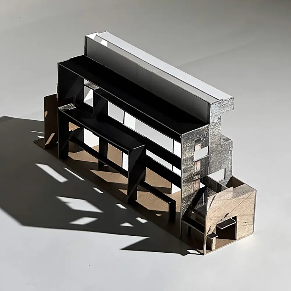 Perspective view of an architectural model showing a long, narrow building with layered black interior floors, concrete‑textured façades, and a small entry volume.