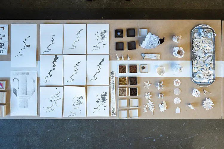 Neatly arranged samples of material research are displayed on a wood surface.