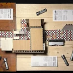 Scale model of 1100 E. Kane surrounded by drawings and flashlights