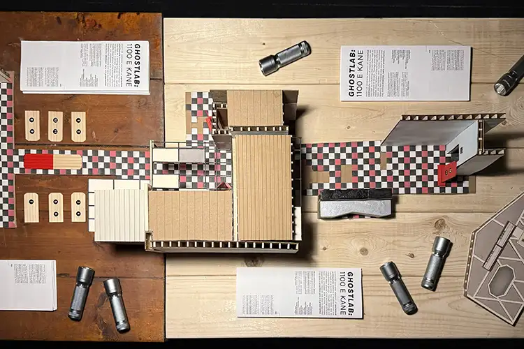 Scale model of 1100 E. Kane surrounded by drawings and flashlights