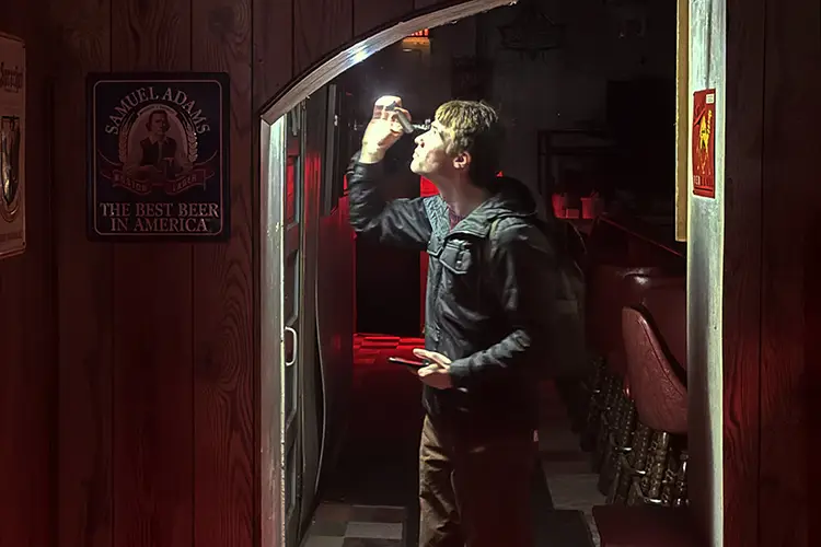 A guest uses a flashlight to investigate "ghosts" in an arched hallway