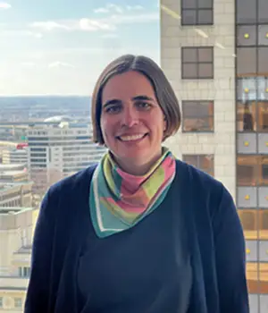 Headshot of Katherine Riordan in front of a city skyline.