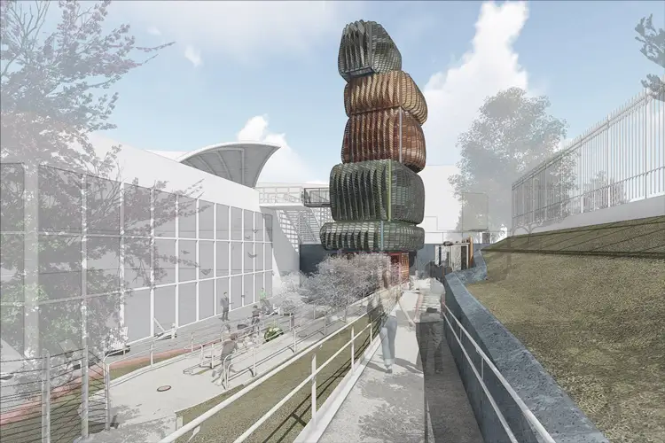 Rendering of an outdoor walkway beside a modern building, featuring a tall stacked sculptural tower with textured, organic forms and people walking below. Rendering of an outdoor walkway beside a modern building, featuring a tall stacked sculptural tower with textured, organic forms and people walking below.