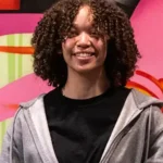 Charlize stands in front of a colorful mural