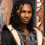 Zion stands against a colorful mural