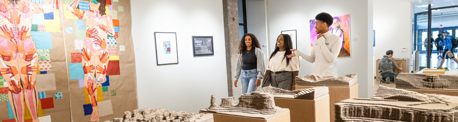 Students in the UWM art gallery looking at different exhibits.
