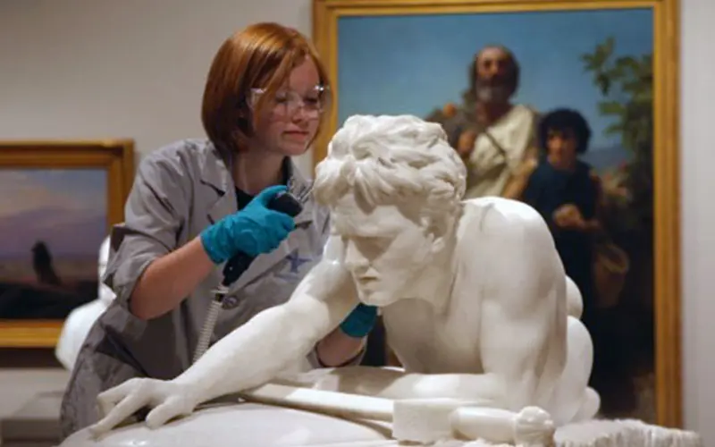 conservator working on sculpture