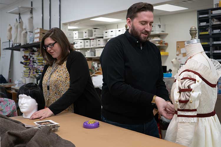 Two faculty members work in the costume shop