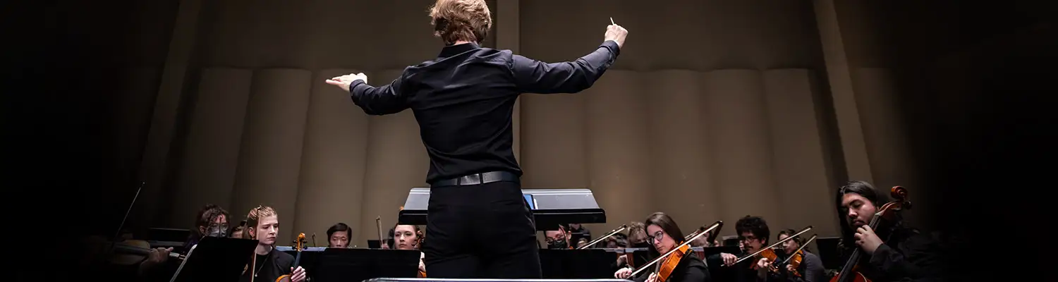 A conductor leads an orchestra during a UWM Symphony Orchestra performance.
