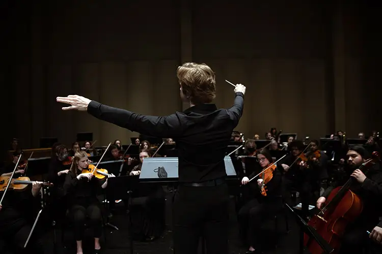 A conductor directs the UWM Symphony Orchestra at the Zelazo Center for the Performing Arts.