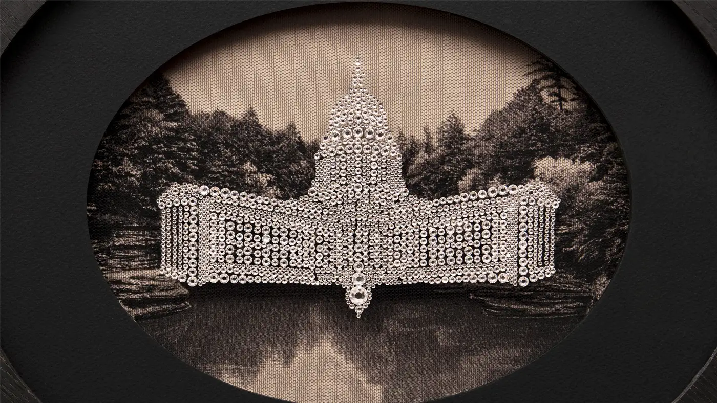 An oval shaped artwork featuring a capitol style building overlaid onto a mountain landscape.
