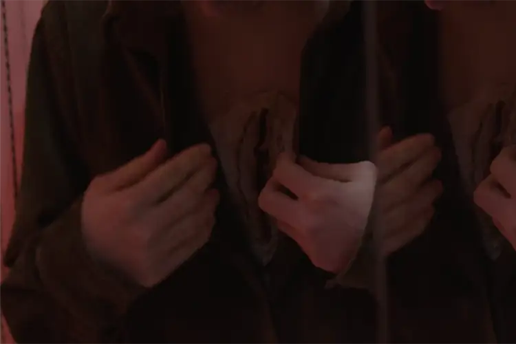 A man opens his shirt in front of a mirror revealing a large crevice in his chest A man opens his shirt in front of a mirror revealing a large crevice in his chest