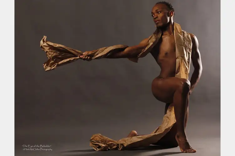 Cotton posed in a lunge with brown paper draped over him. Cotton posed in a lunge with brown paper draped over him.