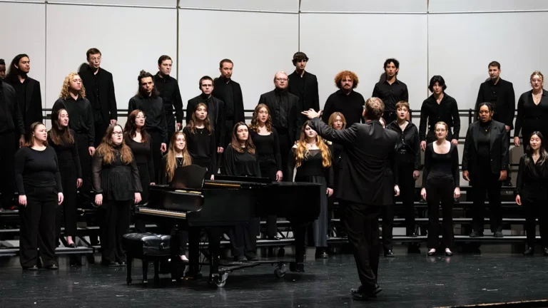 UWM Concert Chorale performing on risers and wearing all black attire at the UWM Zelazo Center.