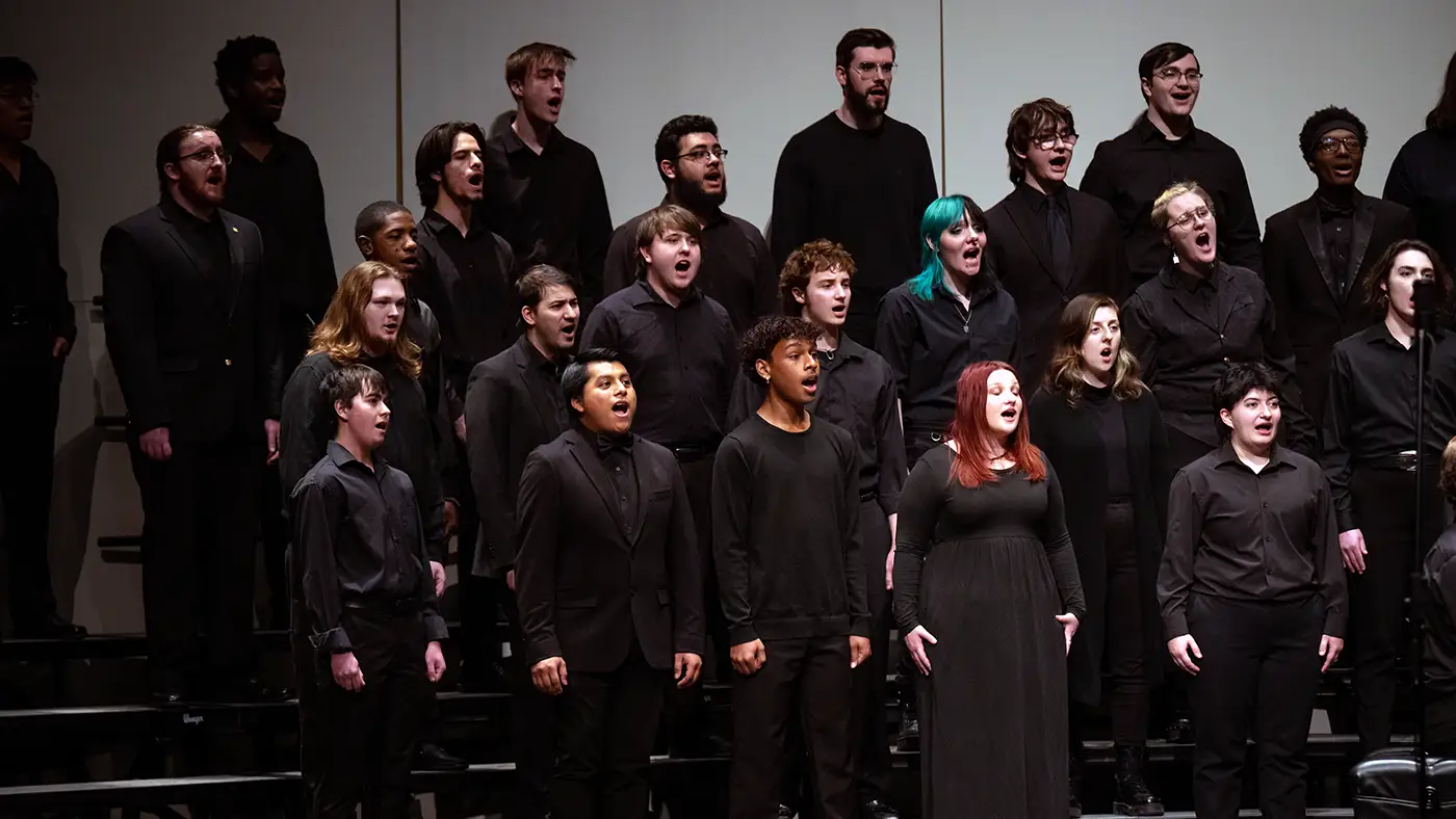 UWM Concert Chorale performing on risers and wearing all black attire at the UWM Zelazo Center.
