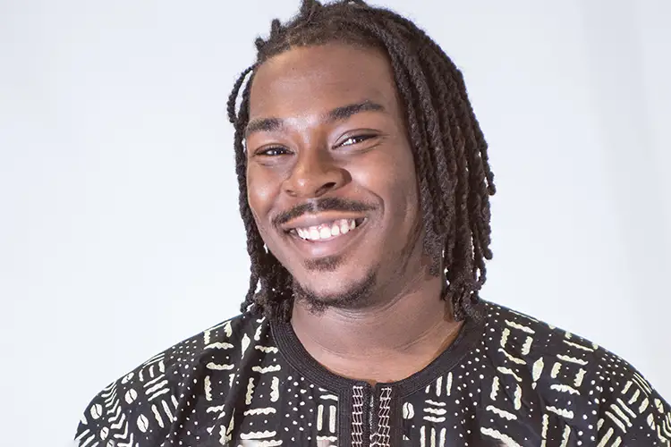 Adrean smiles while wearing a patterned sweater.