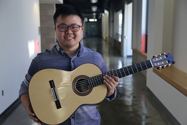 Kevin Loh poses for TMJ4 with his guitar