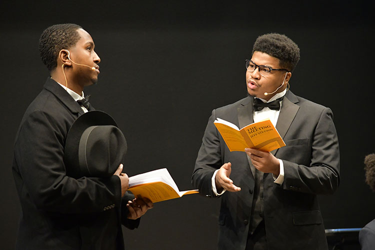 Two students perform in a staged reading.