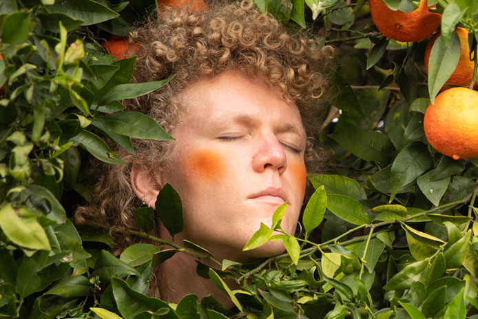 In this self portrait by artist Vaughan Larsen, they are seen surrounded by citrus and greenery.