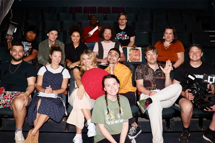 The cast and crew of Earlybird gather for a photo in a screening room.