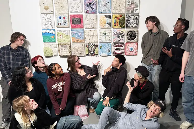 UWM Sculpture students stand in front of a wall showcasing their recent work. UWM Sculpture students stand in front of a wall showcasing their recent work.