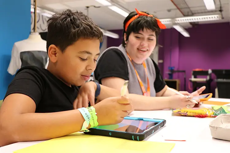 UWM alum and Islands of Brilliance Creative Technologist Ruby Wilson guides a student using Procreate during an Islands of Brilliance Sandbox@ Discovery World Workshop.
