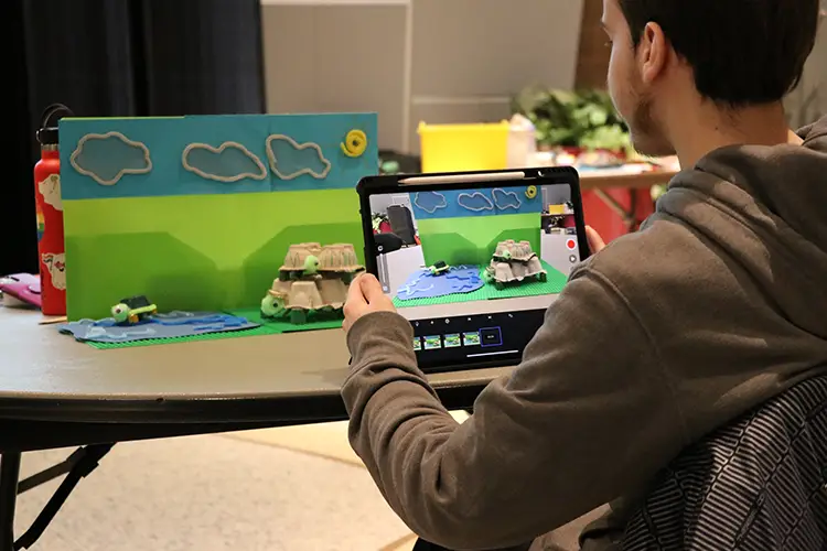 An Islands of Brilliance student creates a stop motion animation using an iPad during a Sandbox@ Milwaukee County Zoo workshop.
