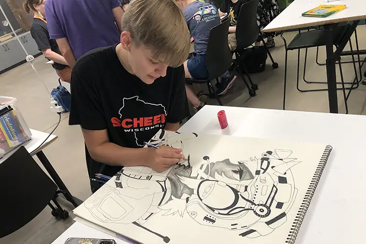 An Islands of Brilliance student works on a project during a Fellowship workshop at the L.E. Phillips Public Library in Eau Claire, WI.