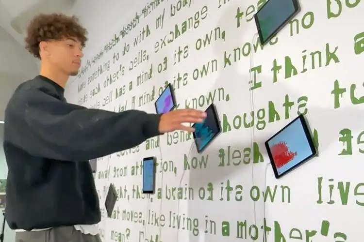 A student interacts with artwork in an exhibition.