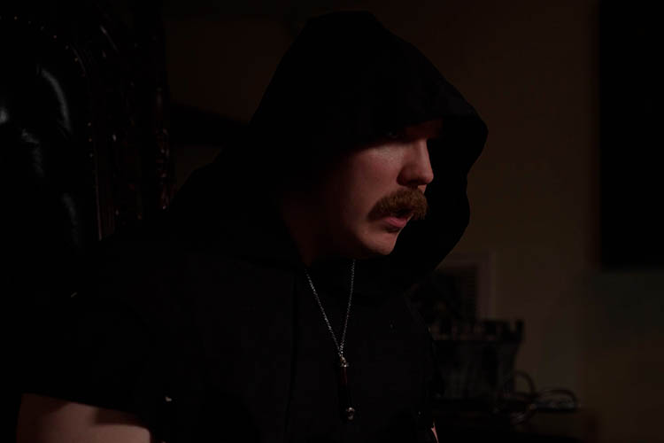 Cloaked man in renisance garb speaks