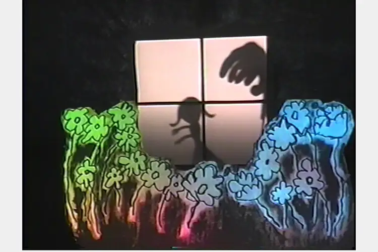 Paper cut outs of flowers in foreground, window with shadow of girl background, with a looming hand.
