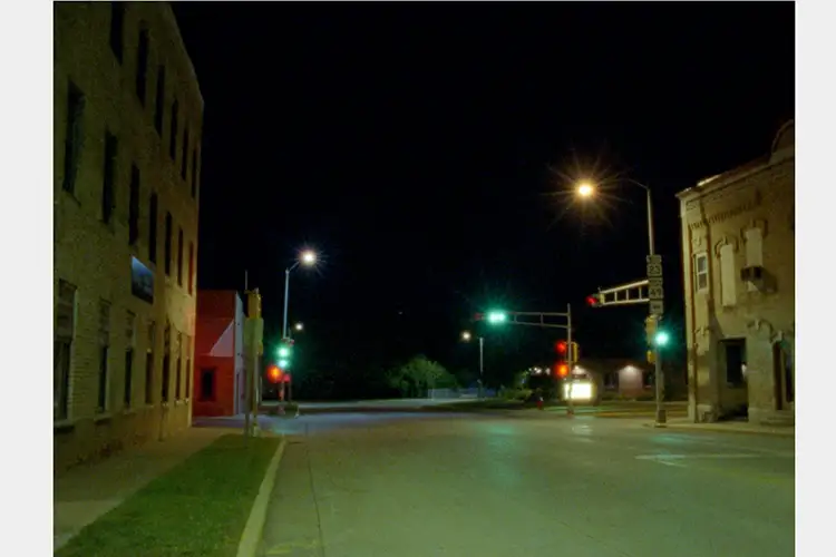 Image of a street at night with lit street lights