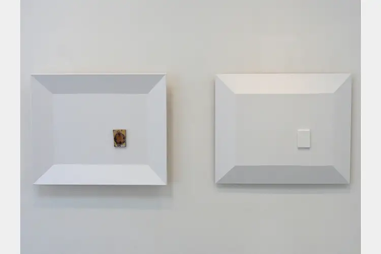 two square plates on the wall with a piece of wood attached to one two square plates on the wall with a piece of wood attached to one