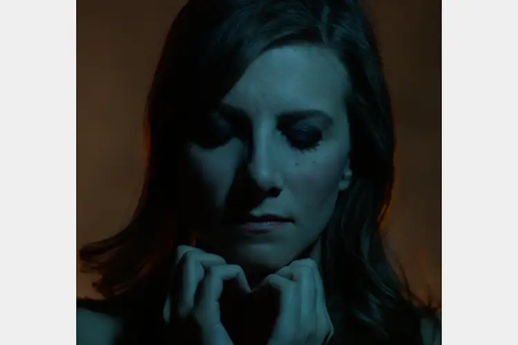 Close up of woman with her eyes closed, lit in soft blue-green Close up of woman with her eyes closed, lit in soft blue-green