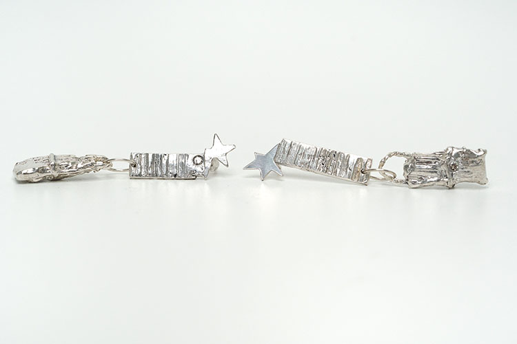 Two silver earrings. Both have two rectangles connected by a small chain and a star at the bottom.