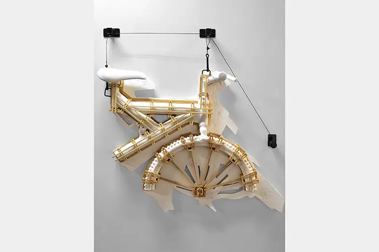 Plaster cast bike in restrictive frame hung on the wall with wires