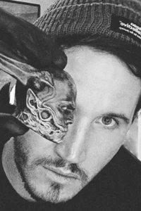 Steve Teeple holds an alien-like figure over his left eye.