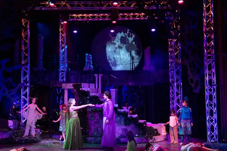 Shades of purple wash the stage during a performance of Rockin' Midsummer Night's Dream.