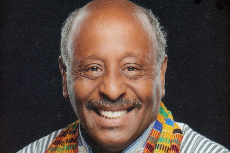 Clayborn Benson smiles against a black background