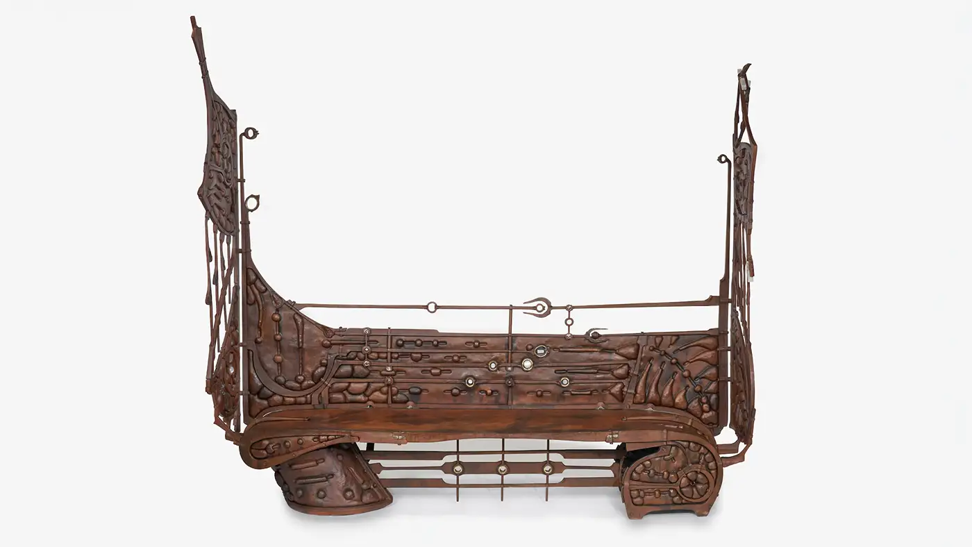 Intricately crafted bench sculpture with mechanical details, gears, rods, and decorative elements.