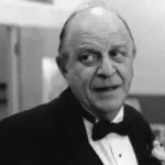 A black and white picture of Dominique North. He is wearing a suit and bowtie.